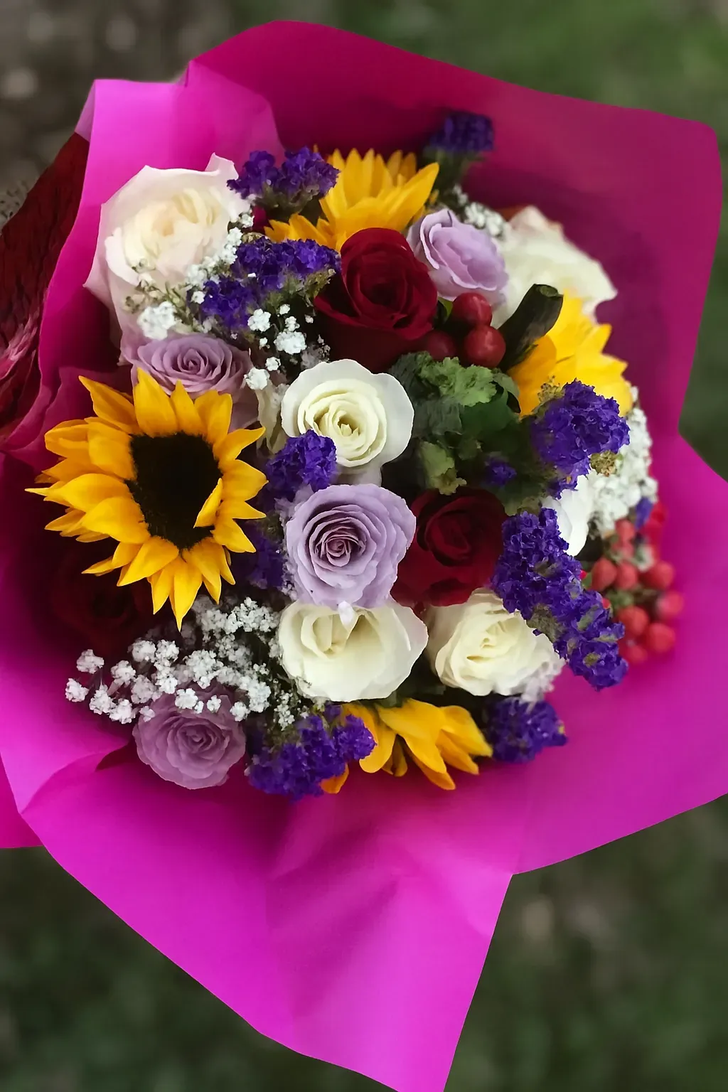 Bouquet de fleurs de deuil coloré composé de roses et de tournesols.
